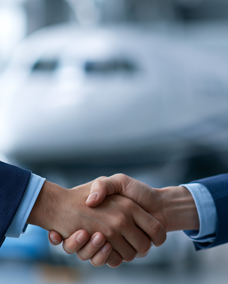 Shaking hands In front of aircraft