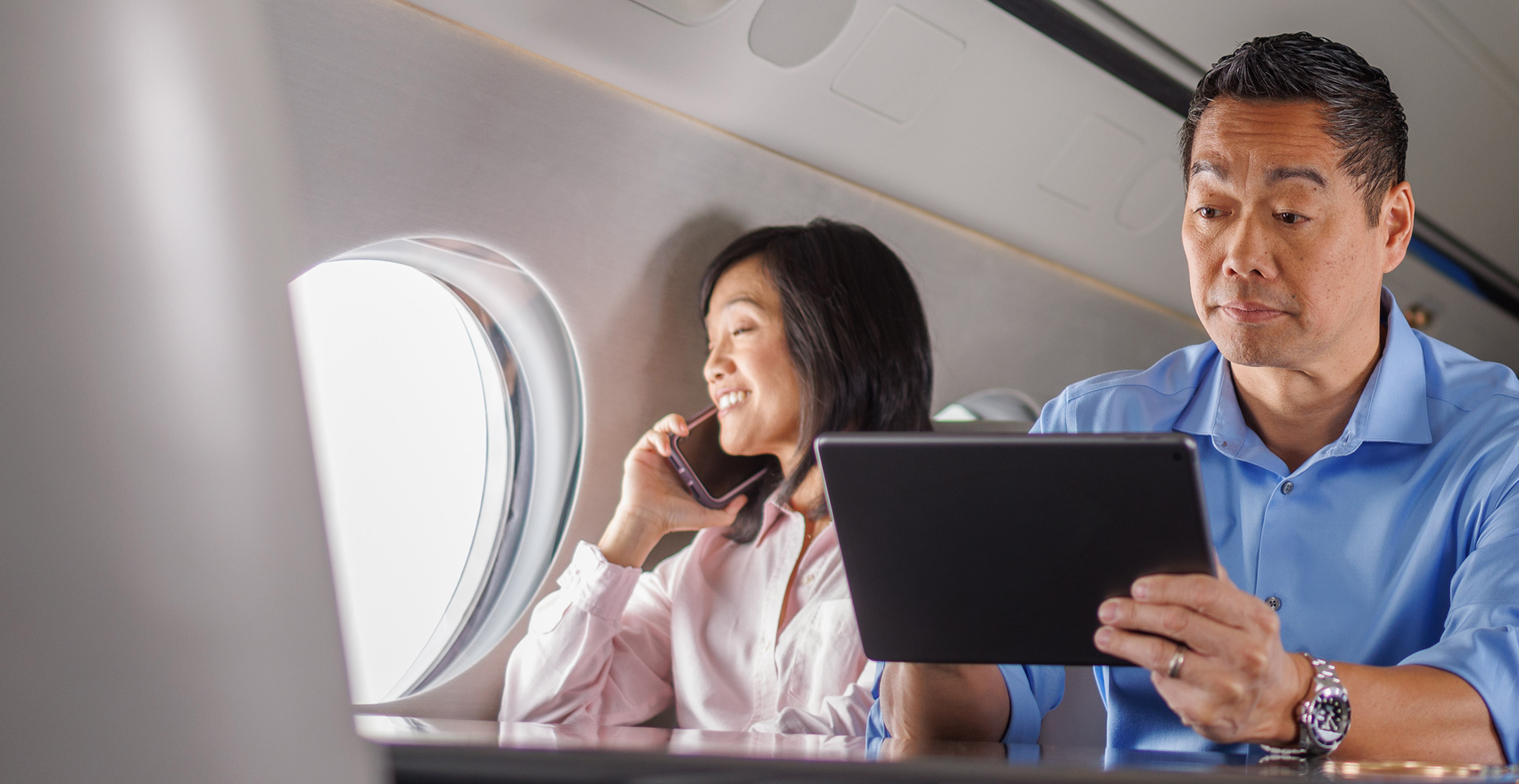 Man on Tablet Woman on Cellphone in Gulfstream aircraft