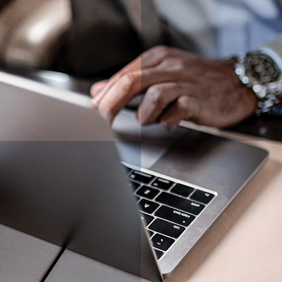 Man with a nice watch seated on an airplane, and using a laptop
