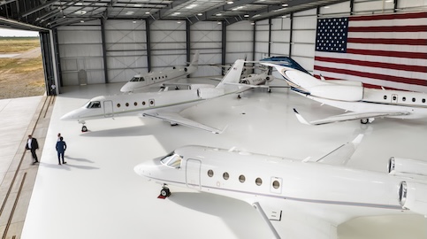 5 planes in hangar with American flag