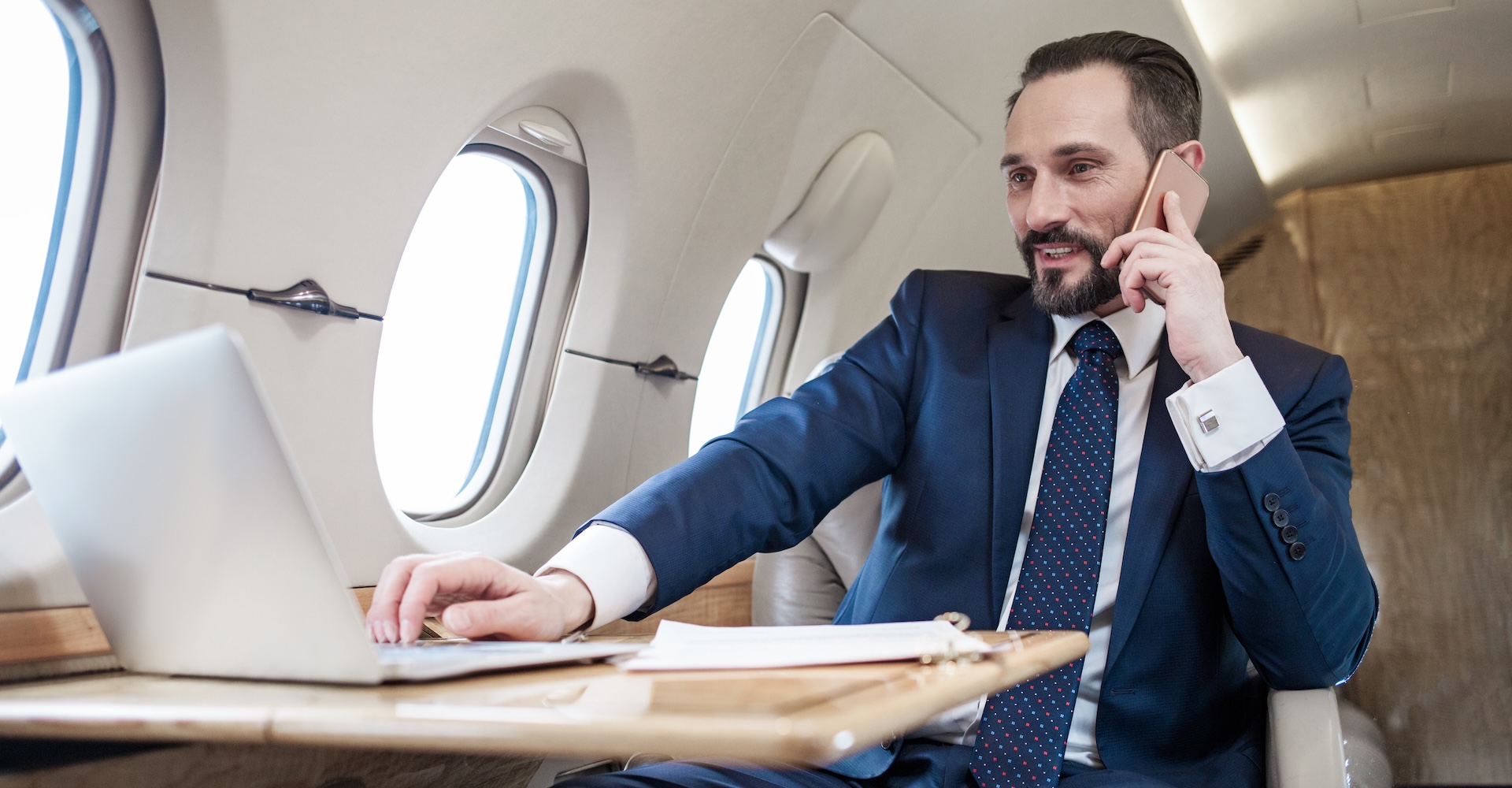 Callout - Man on a phone and laptop in cabin Callout - Man on a phone and laptop in cabin