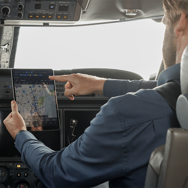 Piloto na cabine olhando para tablet