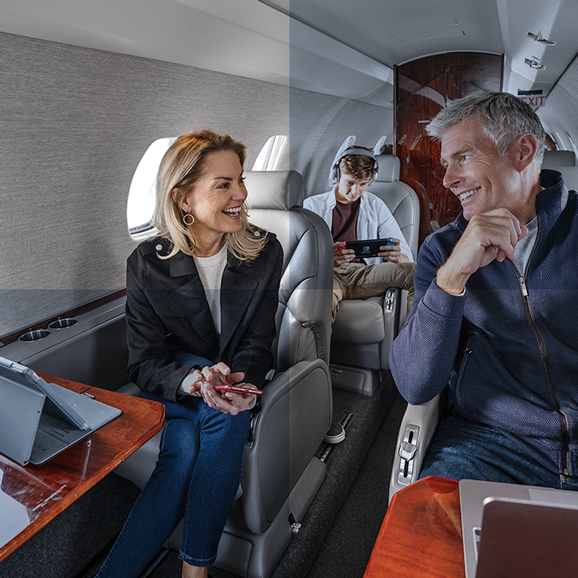 A family of three is flying together, using tablet, phone and game console on a plane